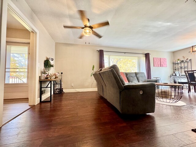 living room featuring dark hardwood / wood-style flooring and ceiling fan