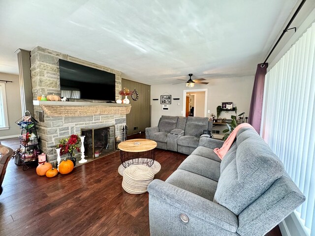 living room featuring dark wood-type flooring, ceiling fan, and a fireplace