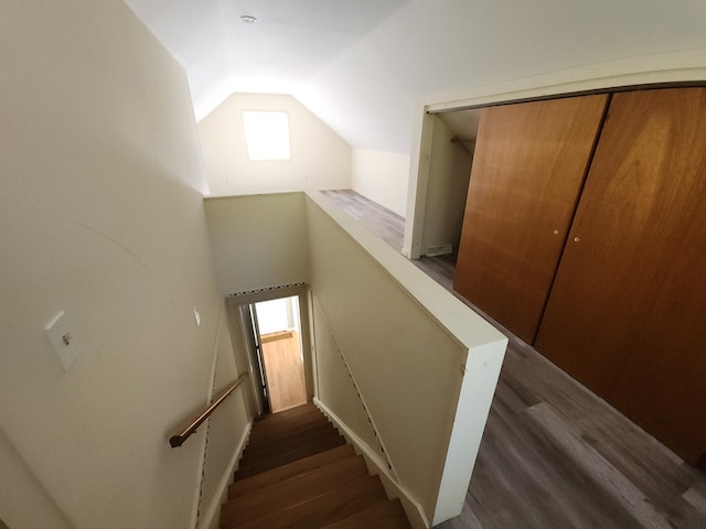 stairs featuring lofted ceiling and wood-type flooring