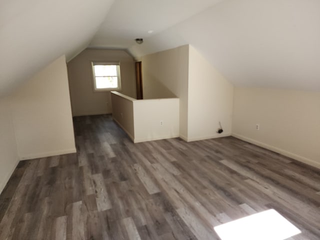 additional living space with lofted ceiling and dark wood-type flooring