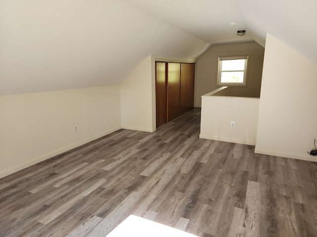 bonus room with lofted ceiling and dark wood-type flooring