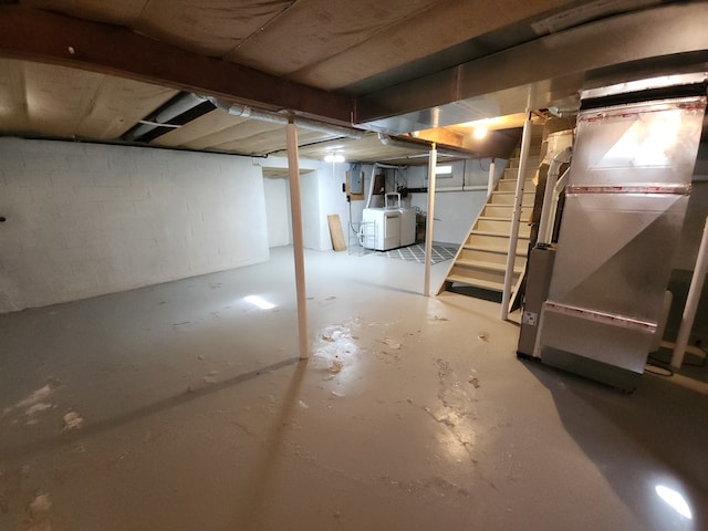 basement featuring heating unit and independent washer and dryer