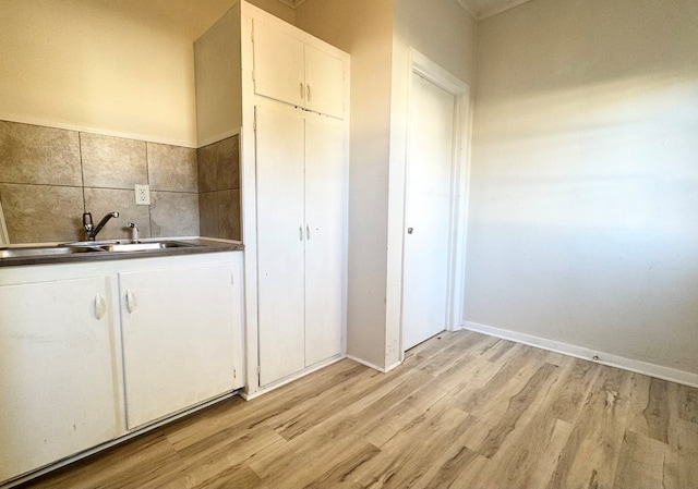 kitchen featuring light hardwood / wood-style floors, white cabinetry, and sink