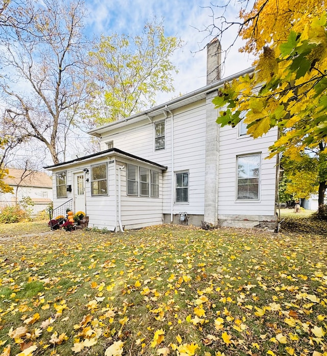 rear view of property featuring a yard