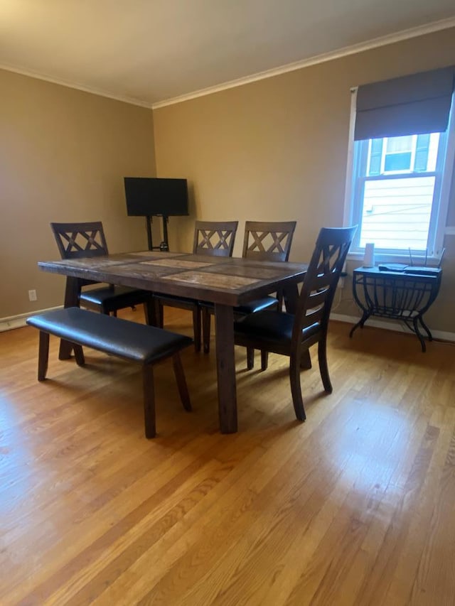 dining room with light hardwood / wood-style floors and ornamental molding