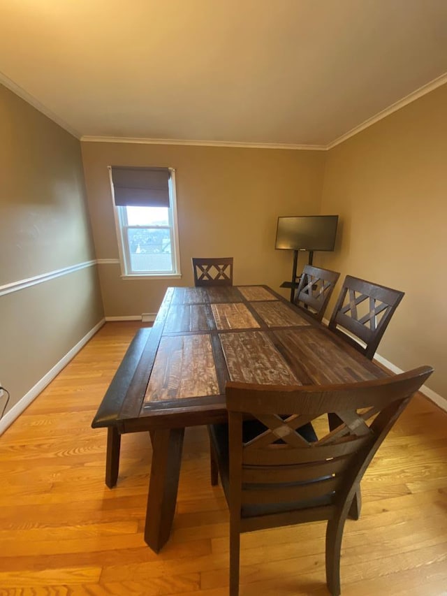 dining area featuring light hardwood / wood-style floors and crown molding