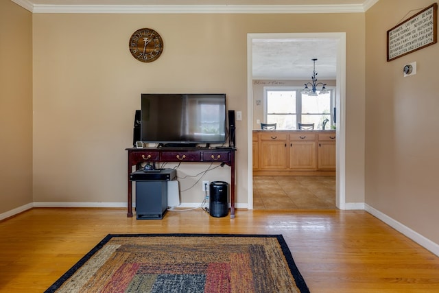 living room featuring crown molding, light hardwood / wood-style flooring, and a chandelier