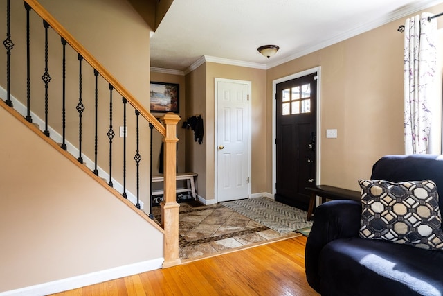 foyer with ornamental molding and light wood-type flooring