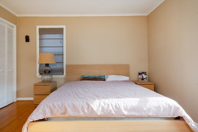 bedroom with crown molding, a closet, and wood-type flooring