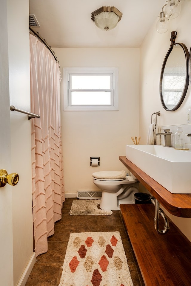 bathroom featuring tile patterned flooring, toilet, and sink