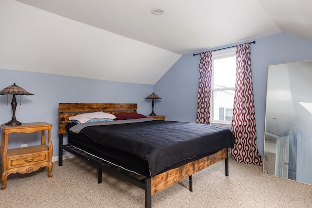 bedroom featuring light colored carpet and vaulted ceiling