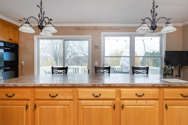 kitchen with a breakfast bar area, sink, decorative light fixtures, and a notable chandelier