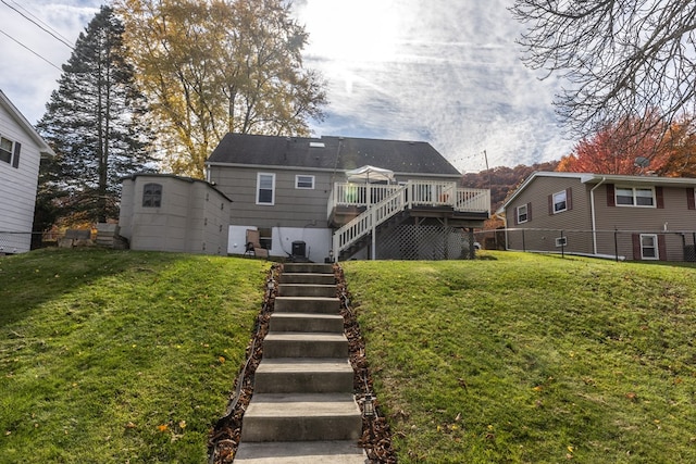 back of property featuring a lawn and a wooden deck