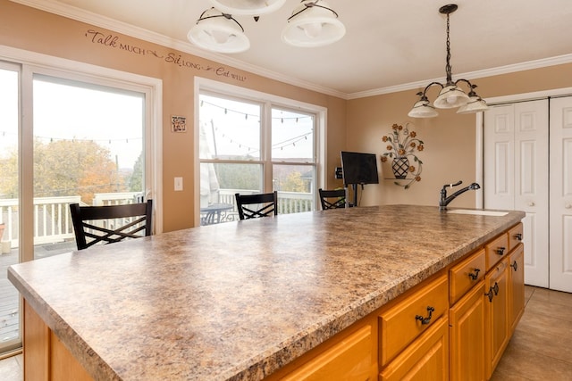 kitchen featuring a kitchen island, a wealth of natural light, ornamental molding, and sink