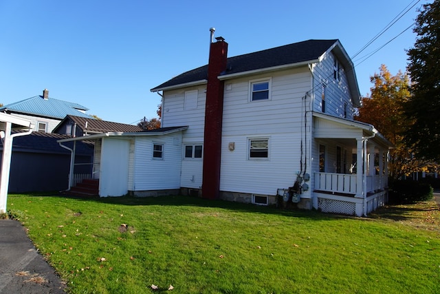 rear view of house featuring a lawn