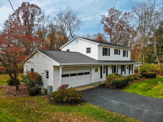 front facade featuring a porch, a garage, central air condition unit, and a front lawn