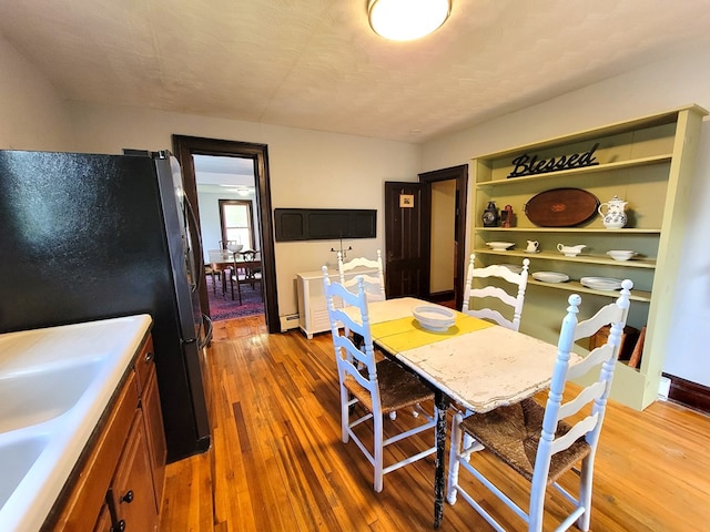 dining space with wood-type flooring and a textured ceiling