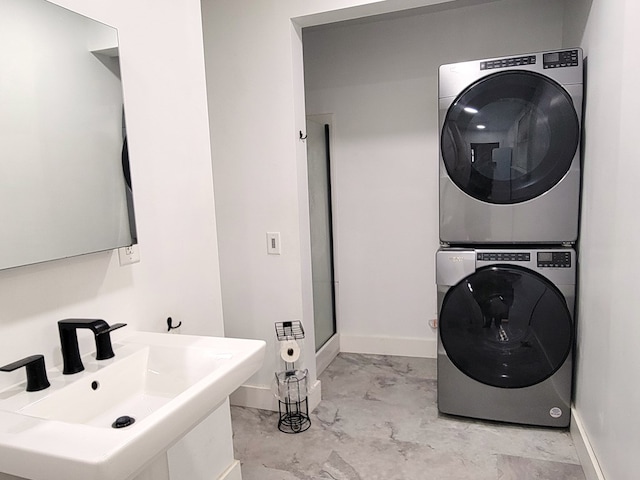 clothes washing area featuring sink and stacked washer and clothes dryer