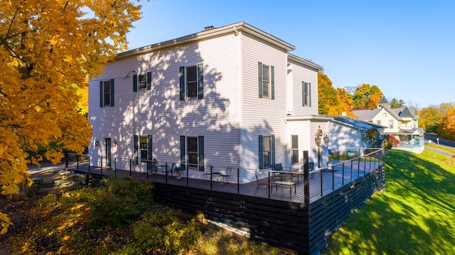 rear view of property featuring a yard and a deck