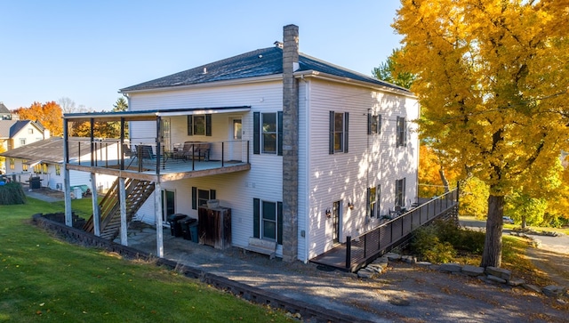 back of property featuring a lawn and a wooden deck