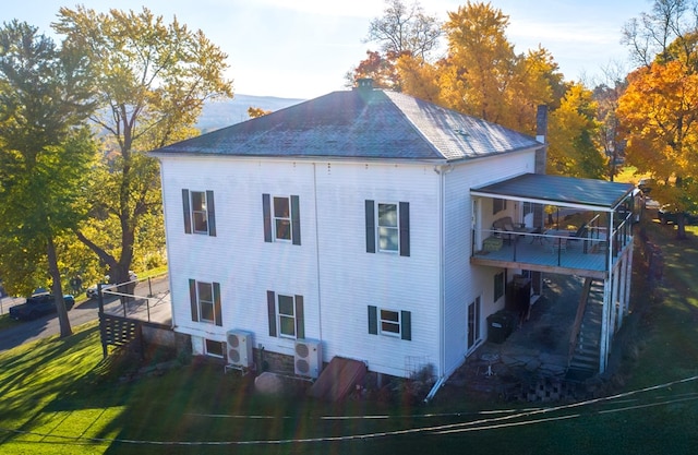 rear view of property featuring a yard and central air condition unit