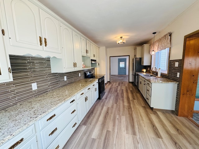 kitchen with black range with electric stovetop, white cabinetry, sink, light hardwood / wood-style floors, and decorative light fixtures