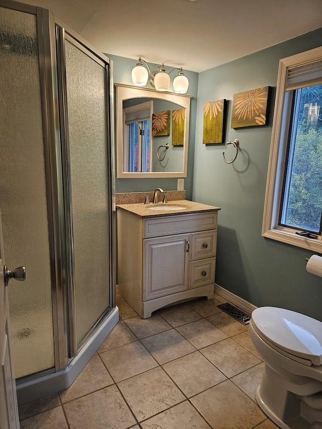 bathroom with toilet, a shower with shower door, tile patterned floors, and vanity