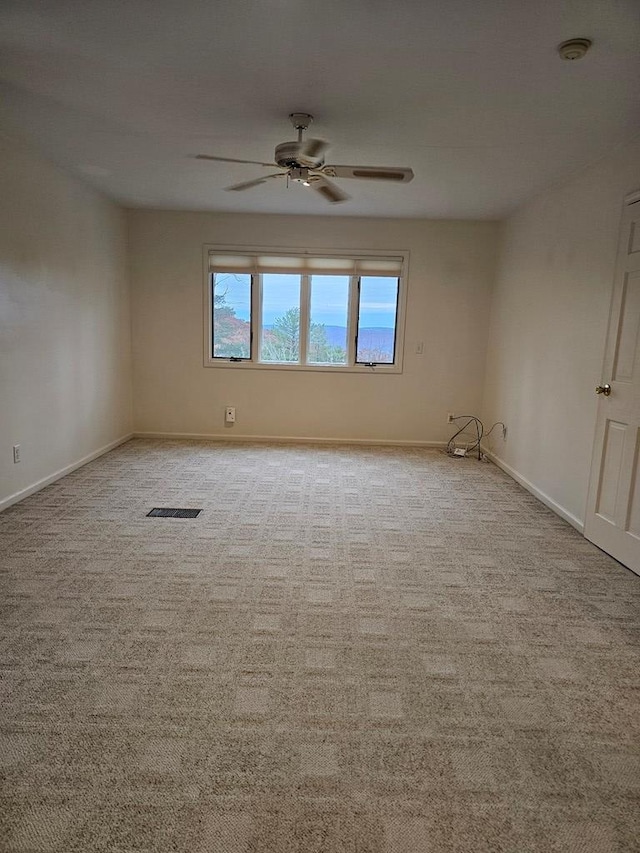 carpeted spare room featuring ceiling fan