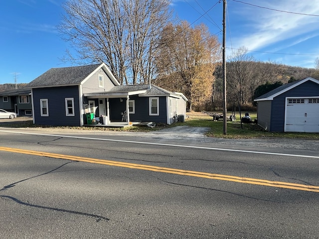 view of front of home featuring an outbuilding, covered porch, and a garage