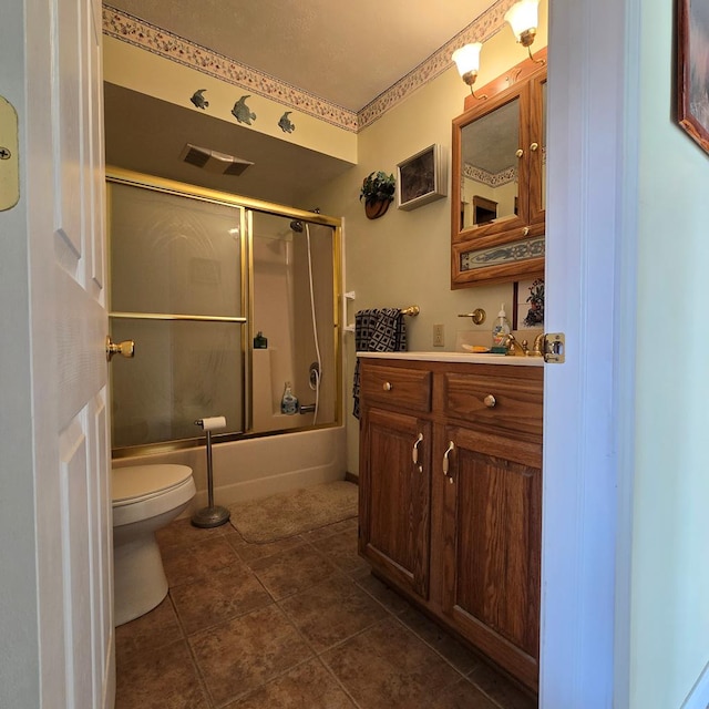 full bathroom featuring vanity, bath / shower combo with glass door, tile patterned floors, and toilet