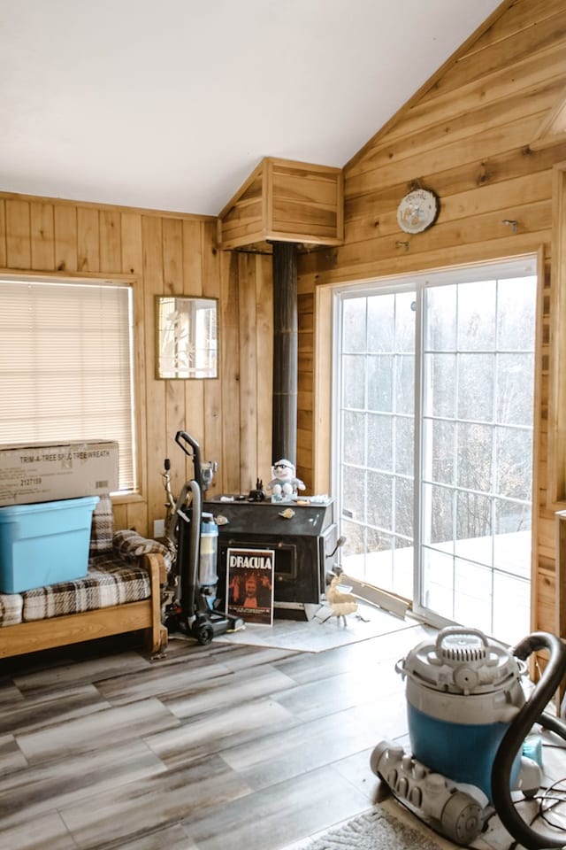 interior space with lofted ceiling, plenty of natural light, and wooden walls