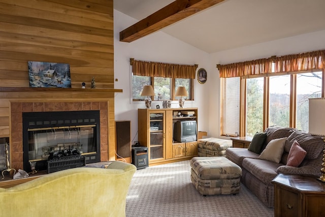 carpeted living room featuring plenty of natural light, a tile fireplace, and vaulted ceiling with beams