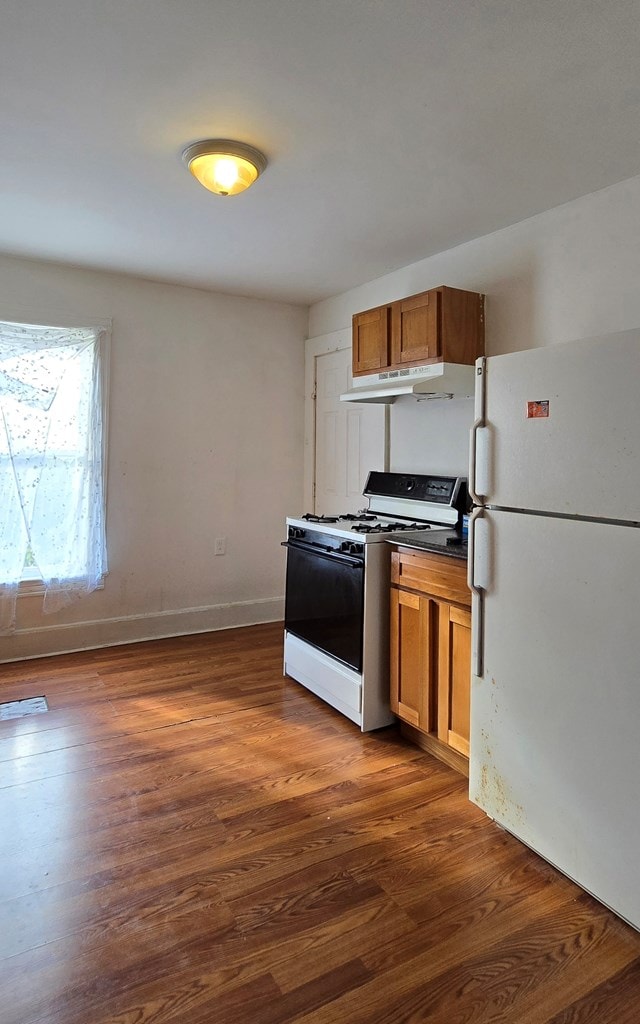 kitchen featuring white appliances and dark wood-type flooring