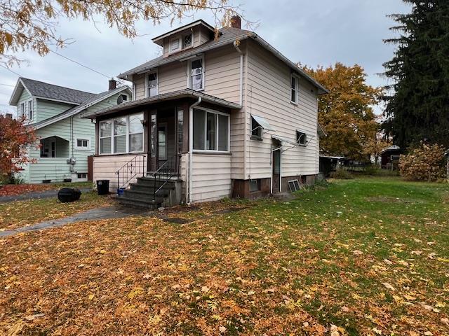 front of property with a sunroom and a front yard