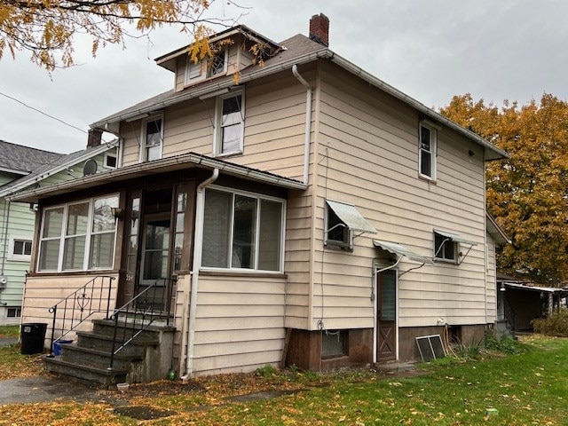 back of property featuring a sunroom and a yard