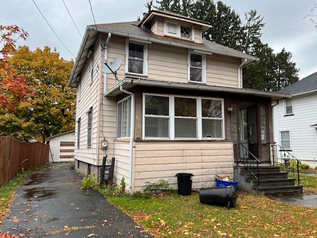 view of front of property featuring a garage and an outdoor structure