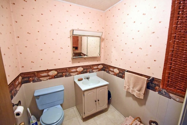 bathroom featuring vanity, tile patterned flooring, ornamental molding, and toilet