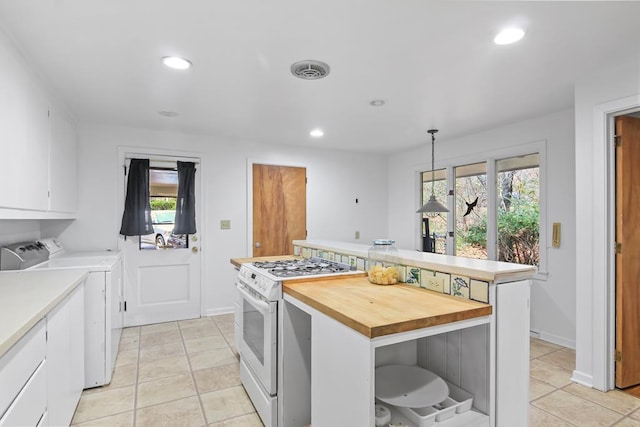 kitchen with white cabinetry, washer and clothes dryer, decorative light fixtures, a kitchen island, and white gas range