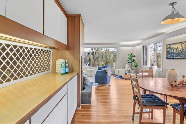 dining area with indoor bar and light hardwood / wood-style flooring