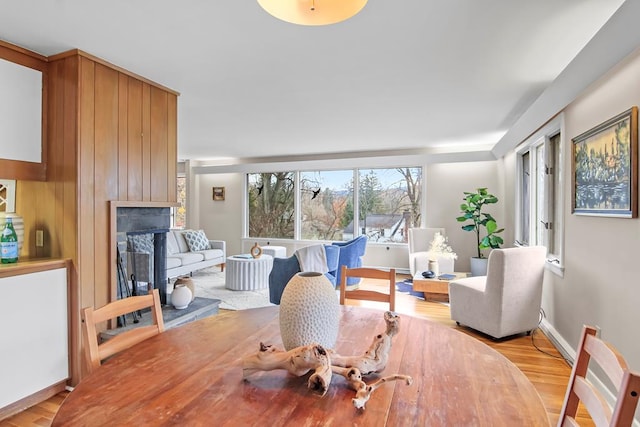 dining area with a large fireplace and light hardwood / wood-style flooring