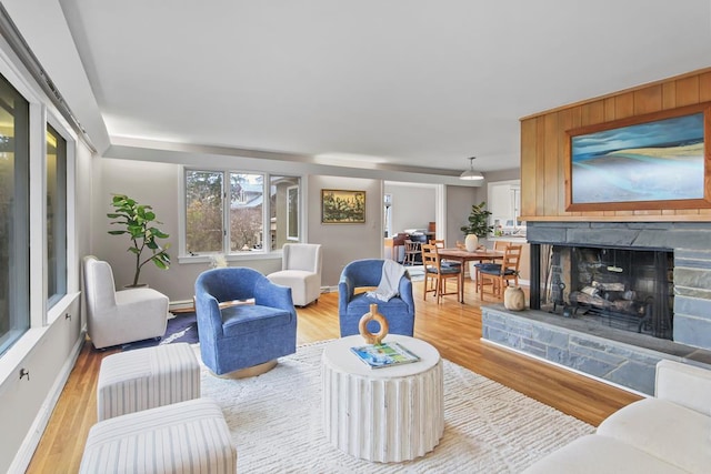 living room featuring wood-type flooring and a stone fireplace