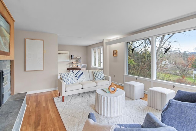 living room with light hardwood / wood-style floors, radiator, and a fireplace