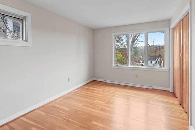 unfurnished bedroom with light wood-type flooring and a baseboard radiator