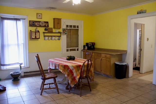 tiled dining area featuring crown molding, a baseboard heating unit, and ceiling fan