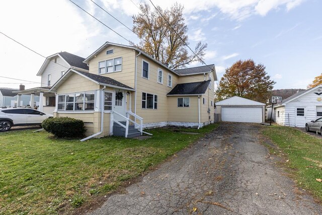 view of front of home featuring an outbuilding, a garage, and a front yard