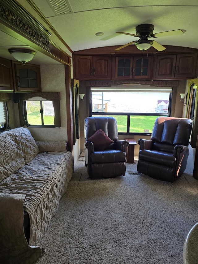 living room with carpet flooring, ceiling fan, and vaulted ceiling