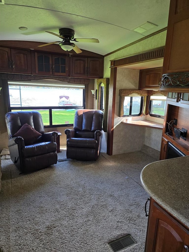 living room with ceiling fan and carpet flooring