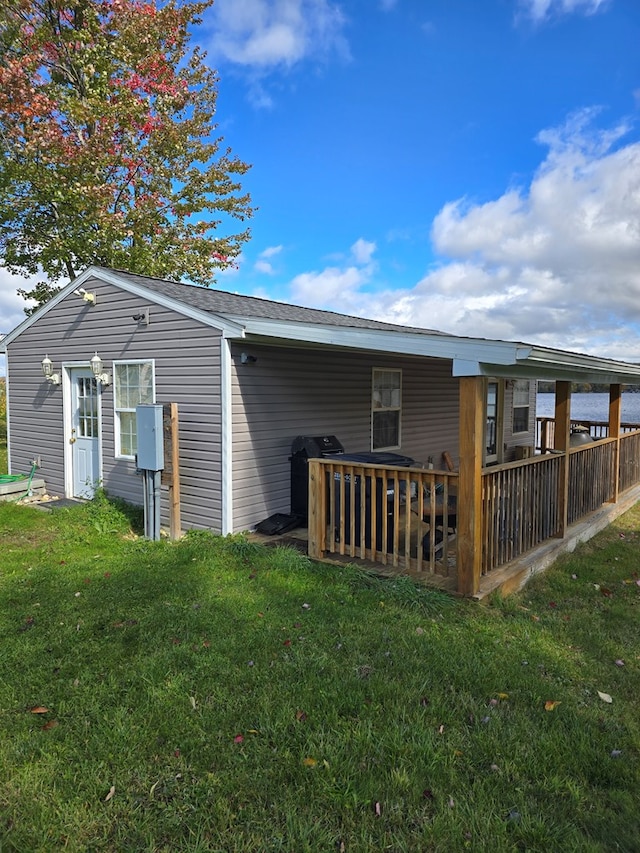 rear view of house with a deck and a lawn