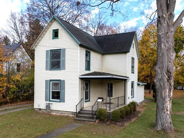 view of property with a porch and a front lawn