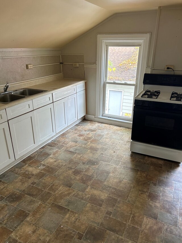 kitchen featuring lofted ceiling, sink, range with gas cooktop, decorative backsplash, and white cabinets